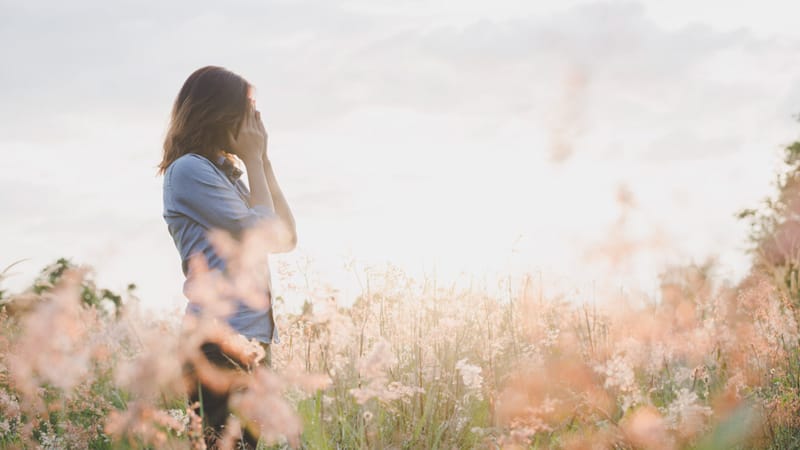 Sad woman standing in field with sunset background. Sad woman standing in field with sunset background.